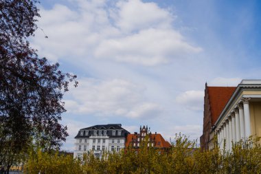 Wroclaw 'da arka planda gökyüzü olan binalar ve ağaçlar