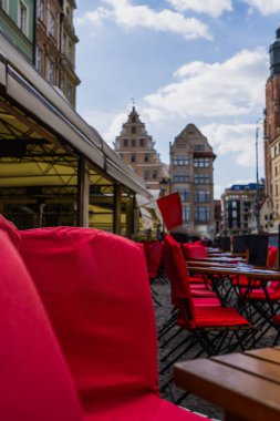 Wroclaw 'daki şehir sokağındaki açık kafe yakınlarında sandalye ve masalar.