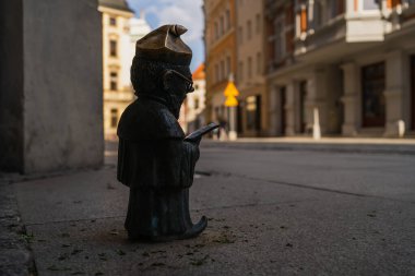 WROCLAW, POLAND - 18 Nisan 2022: Bulanık şehir caddesinde yürüyen cüce heykeli