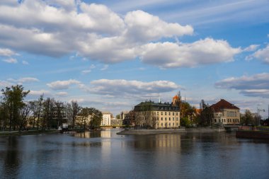 Buildings and river with sky at background in Wroclaw clipart