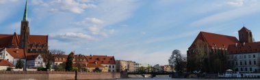 Bridge above river and buildings on Ostrow Tumski in Wroclaw, banner  clipart