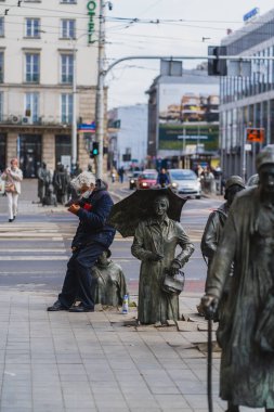 WROCLAW, POLAND - APRIL 18, 2022: People near Anonymous Pedestrians memorial on urban street  clipart