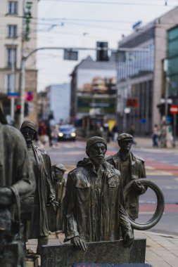 WROCLAW, POLAND - APRIL 18, 2022: Bronze statues of Anonymous Pedestrians memorial on urban street  clipart