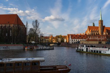 WROCLAW, POLAND - APRIL 18, 2022: Boats on river near Ostrow Tumski at daytime  clipart