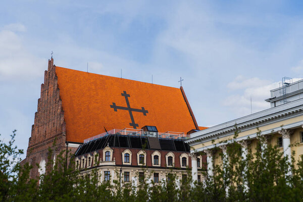 Church St Dorothea near buildings and blurred bushes in Wroclaw