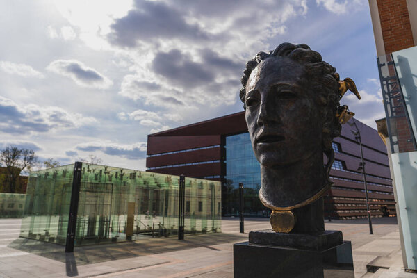 WROCLAW, POLAND - 18 апреля 2022 года: Бронзовая скульптура и Национальный музыкальный форум на заднем плане на городской улице 
