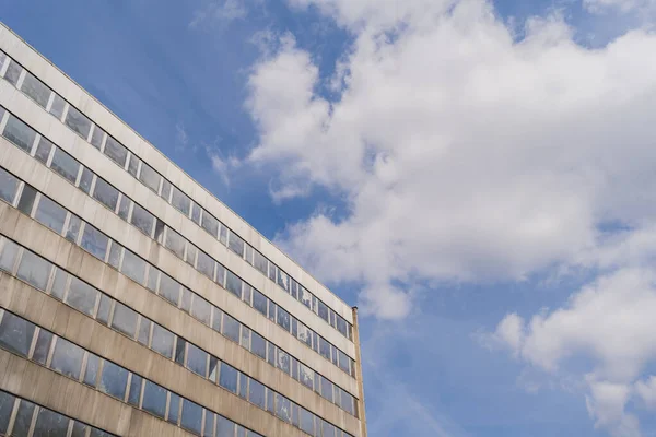 Vista ad angolo basso della facciata dell'edificio e cielo nuvoloso sullo sfondo — Foto stock