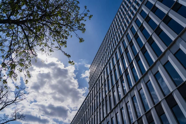 Vista de ángulo bajo de la fachada del edificio y el cielo nublado en el fondo en Wroclaw - foto de stock