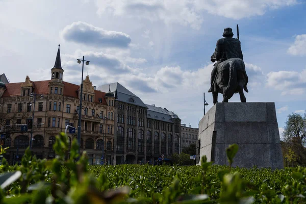 Monument près des plantes et bâtiment sur la rue urbaine à Wroclaw — Photo de stock