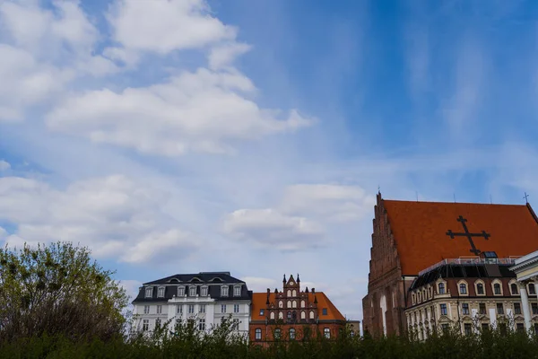 Церковь Святой Доротеи возле зданий с небом на заднем плане во Вроцлаве — стоковое фото