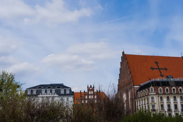 Edificios antiguos y la iglesia de Santa Dorotea con el cielo al fondo en Wroclaw - foto de stock