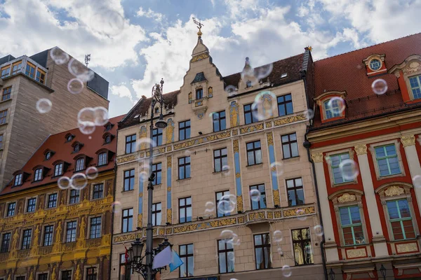 Низкий угол обзора размытых мыльных пузырей на городской улице во Вроцлаве — стоковое фото