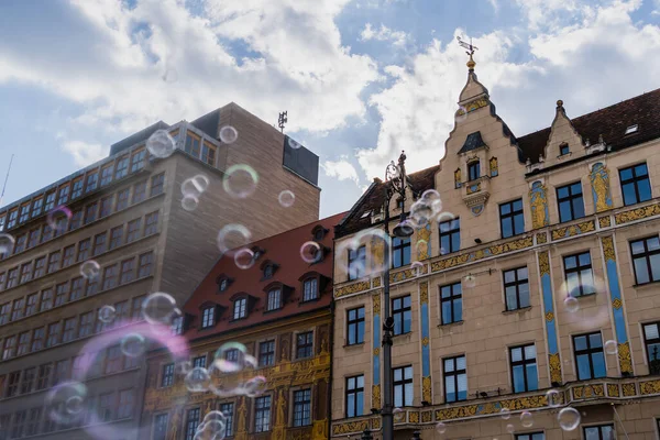 Niedriger Blickwinkel auf verschwommene Seifenblasen und Gebäude auf der Straße in Breslau — Stockfoto