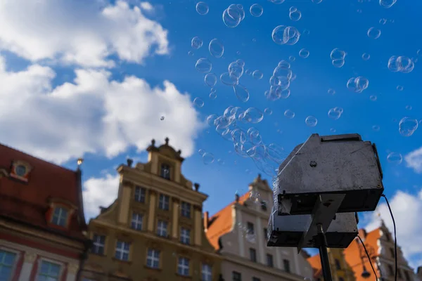 Vista en ángulo bajo del aparato de burbujas de jabón en la calle urbana borrosa en Wroclaw - foto de stock