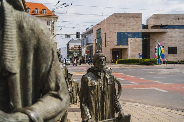 WROCLAW, POLONIA - 18 DE ABRIL DE 2022: Esculturas de bronce del memorial de peatones anónimos en la calle urbana - foto de stock