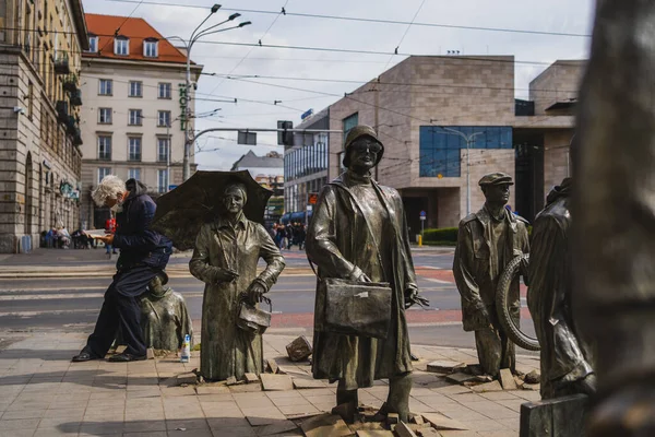 WROCLAW, POLONIA - 18 DE ABRIL DE 2022: Vista de las esculturas de peatones anónimos en la calle urbana - foto de stock