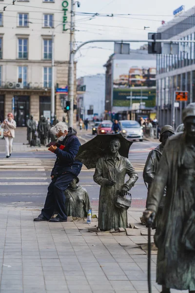 WROCLAW, POLAND - APRIL 18, 2022: People near Anonymous Pedestrians memorial on urban street — Stock Photo