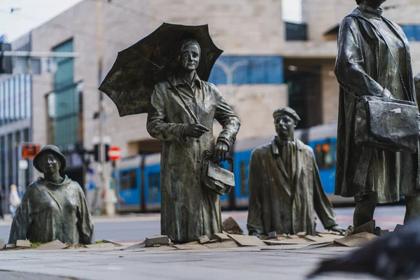 WROCLAW, POLONIA - 18 DE ABRIL DE 2022: Monumento a las esculturas de peatones anónimos en la calle urbana - foto de stock
