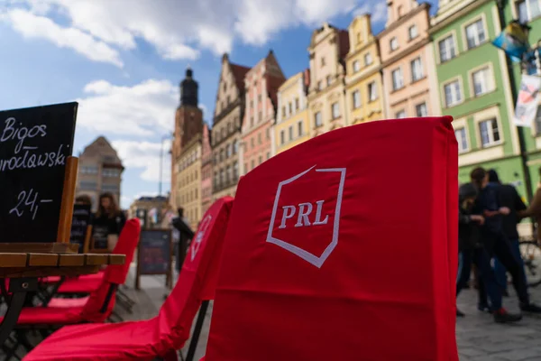 WROCLAW, POLONIA - 18 DE ABRIL DE 2022: Sillas y mesas en la cafetería al aire libre en la calle urbana - foto de stock