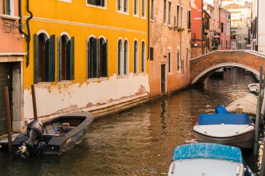 Venedik, İtalya 'da kanal ve teknenin yanındaki bir binanın sarı renkli cephesi