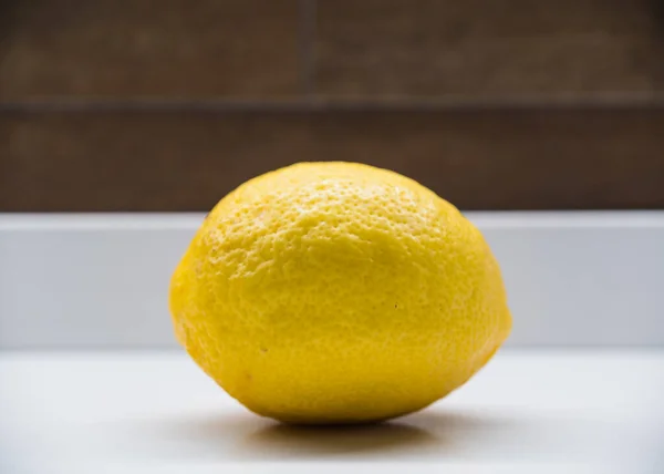 Mutfak tezgahındaki izole edilmiş sarı limonu kapat. 