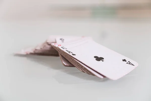 closeup detail of a tiny deck of cards on a white reflective surface