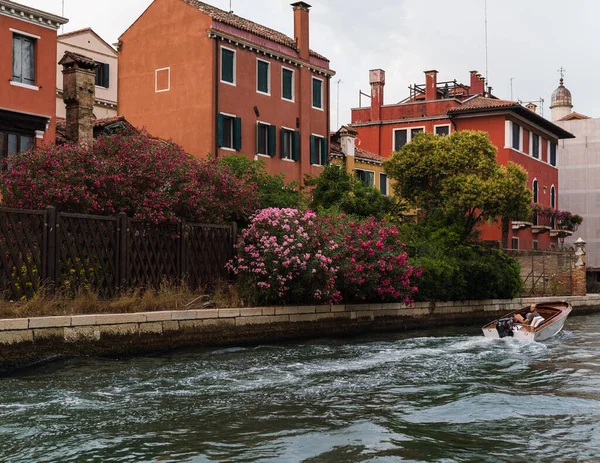 Venedik, İtalya 'da ve renkli evlerde yol alan bir tekne.