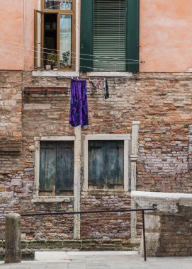 Çamaşırlar kurumak için Venedik, İtalya 'da bir kanalda asılı kalmış ve arka planda köprü var.. 