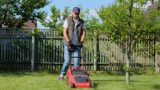 Bonito Jardineiro Masculino Cortando Grama Com Cortador Grama Elétrico Jovem — Vídeo de Stock