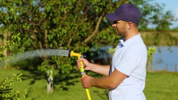 Portrait Young Handsome Male Holding Hose Watering Plant Garden Lake — Stock video