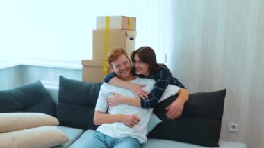 Camera moving back from young cheerful couple of new owners of the apartment. Happy family bought new house and feeling excited on moving day. Mortgage. Man showing keys to new home. Slow motion
