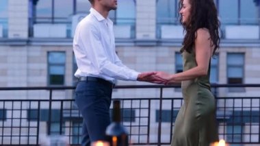 Genç ve zarif bir çiftin portresi çatıda dikilmiş romantik zaman geçiriyorlar. Sevgi ve şefkat. Erkek arkadaş ve kız arkadaş nazikçe sarılıyorlar..