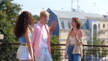 Genç neşeli güzel insanlar güneşli bir yaz gününde dışarıda durup erkek arkadaşlarıyla keyifli bir şekilde konuşuyorlar. Kafkas gençliği birlikte zaman geçiriyor. Şehir yaşam tarzı. Arkadaşlık kavramı