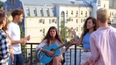 Dertsiz gençler çatıdaki bir partide bira eşliğinde eğleniyor. Güzel bayan müzisyen açık havada gitar çalarken Kafkas gençlik dansı. Yaz tatili aktivitesi. Yavaş çekim