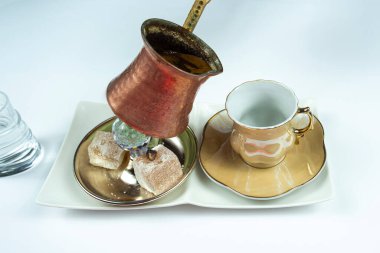 Geleneksel çaydanlıktan Türk kahvesi, zevkli Türk kahvesi servisi, konsept servis, sıcak kahve içmek, yan görüş, beyaz arka planda izole edilmiş
