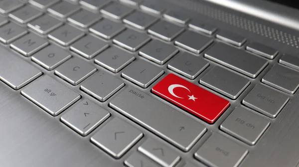 Keyboard with Turkey flag on the enter button, represents cyberattack of Turkey, metaphor of learning Turkish language, grey keypad close up, front view, selective focus