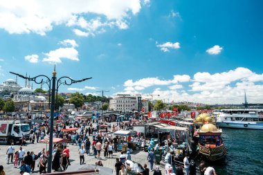 Eminonu Meydanı 'ndaki kalabalık, arka planda mavi bulutlu gökyüzü, kalabalık ve yoğun fikir, İstanbul' daki ünlü varış yeri, deniz ve balıkçılarla dolu şehir manzarası