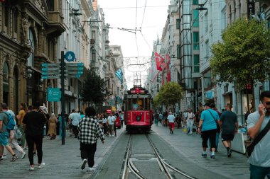 Istiklal Caddesi 'ndeki kırmızı tramvay manzarası, İstanbul' daki şehir manzarası, popüler kırmızı tramvay görüntüleri, yürüyen insanlarla dolu retro sokak, kalabalık yolda giden eski tren: Taksim, İstanbul, Türkiye