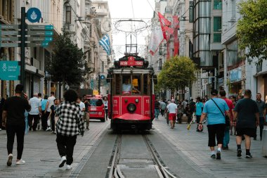 Istiklal Caddesi 'ndeki kırmızı tramvay manzarası, İstanbul' daki şehir manzarası, popüler kırmızı tramvay görüntüleri, yürüyen insanlarla dolu retro sokak, kalabalık yolda giden eski tren: Taksim, İstanbul, Türkiye
