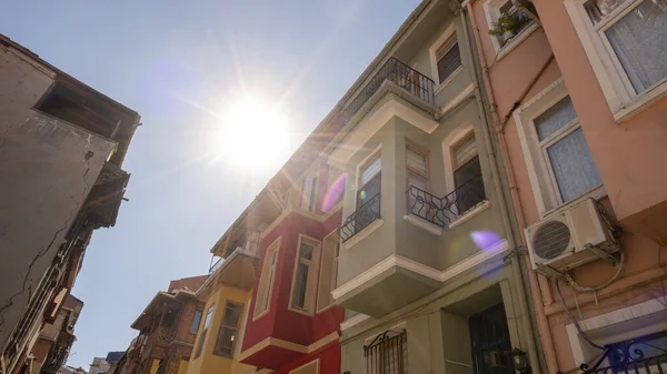 Colorful buildings in Balat with sunlight in background, travel and explore in Istanbul, beautiful colored buildings, popular sightseeing location in Istanbul, blue sky with sunbeam