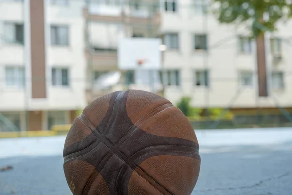 バスケットボールのフープと建物 ストリートバスケットボールのコンセプト 人々のバスケットボールコート 郊外と屋外スポーツのアイデアを持つ選択的フォーカスバスケットボールボール — ストック写真