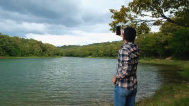 Sakallı adam ormanda sinyal bulmaya çalışıyor, doğada cep telefonu kullanıyor, 4k 60 fps video, sinyal yok, ormanda kaybolmuş, sinyal arayan genç adam, kablosuz internet bağlantısı hatası