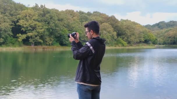 Giovane Uomo Che Scatta Foto Del Lago Con Una Fotocamera — Video Stock