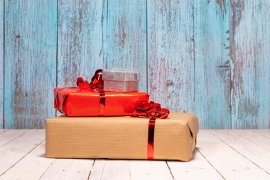 En iyi dilekleriniz için bir sürü hediye ve fotokopi alanı içeren kompozisyon. Sevgi dolu bir Noel için beyaz ahşap bir masada kırmızı, kahverengi ve gümüş hediye kutuları. Noel konsepti