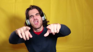 Müzik dinleyen bir adam. Kulaklıklı genç adam dans ederken müzik dinliyor ve şarkı söylüyor..