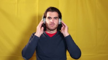 Müzik dinleyen bir adam. Kulaklıklı genç adam dans ederken müzik dinliyor ve şarkı söylüyor..