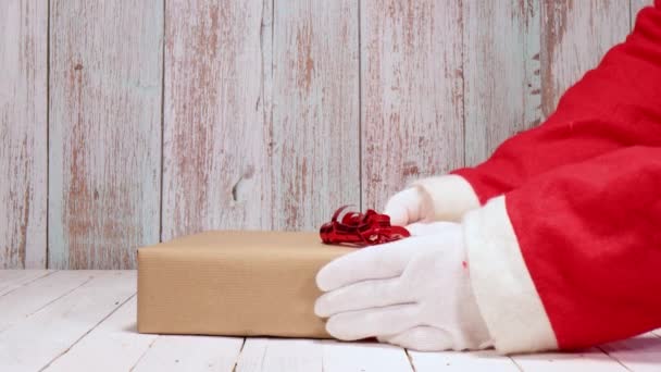 Vánoční Nápad Santa Claus Dává Tři Dárky Bílý Dřevěný Stůl — Stock video