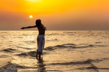 Banyo giysileri ile denizde güzel bir kadın belime sarılıyor. Kadın kollarını açmış suyun içinde dans ediyor. - Ne? Mesajınız için alanı kopyala.