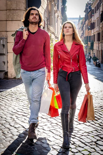 로마로 여행하는 아름다운 부부는 색종이 가방을 쇼핑을 역사적 중심지의 거리를 — 스톡 사진