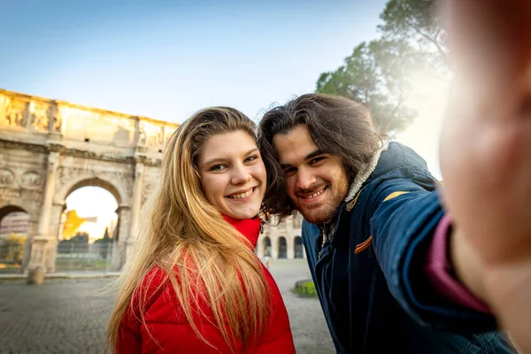 Peynir deyin! Genç ve çekici bir çift Roma 'nın tarihi merkezinde Titus Kemeri' nin yanında selfie çekiyor..